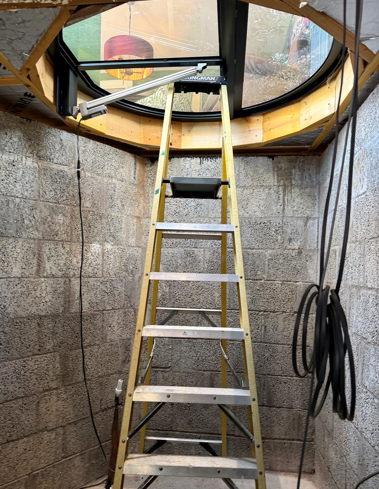 New below-ground wine cellar reached by ladder before the bespoke spiral staircase is fitted, Scotland